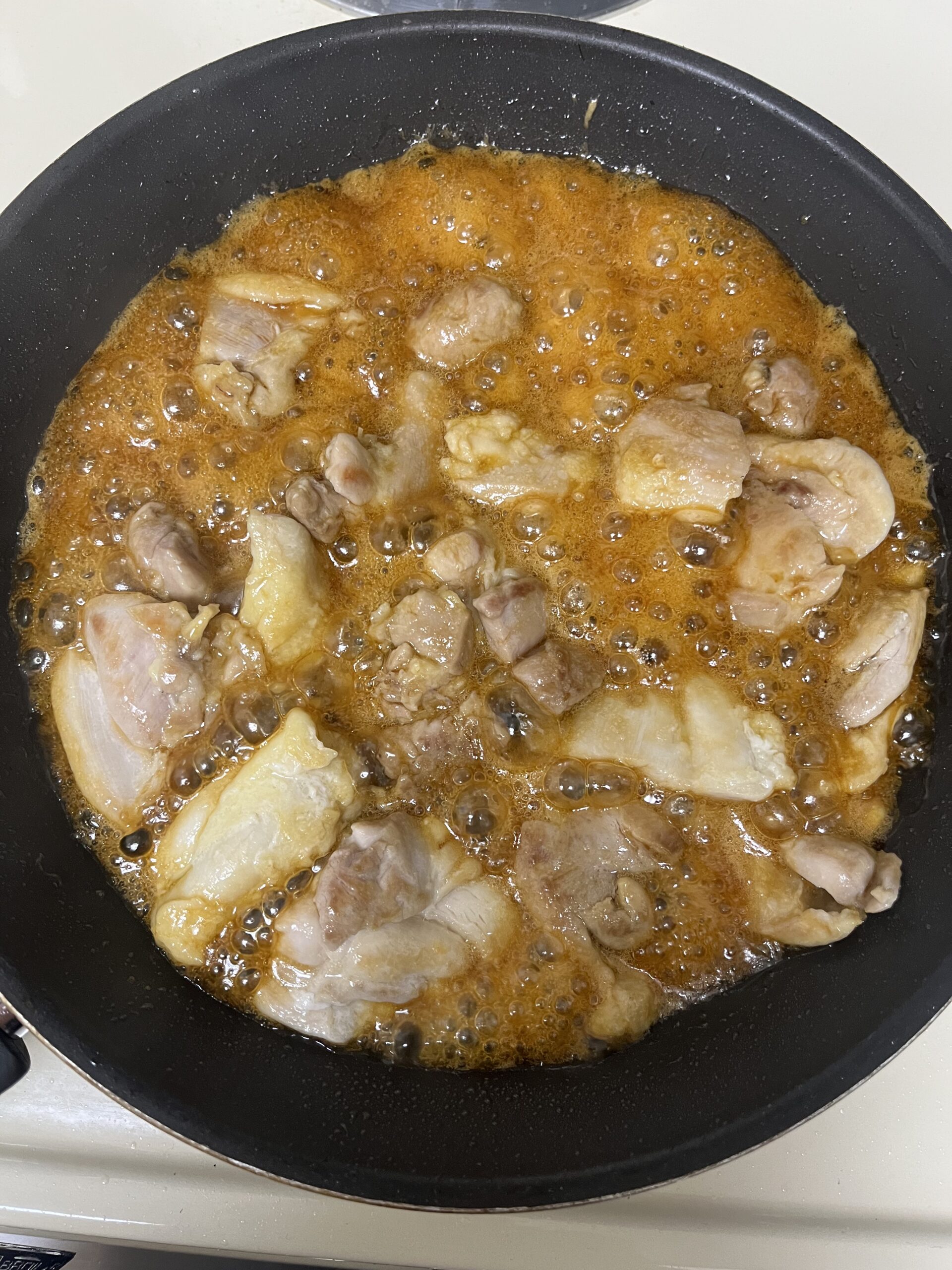 Simmering chicken in teriyaki sauce
