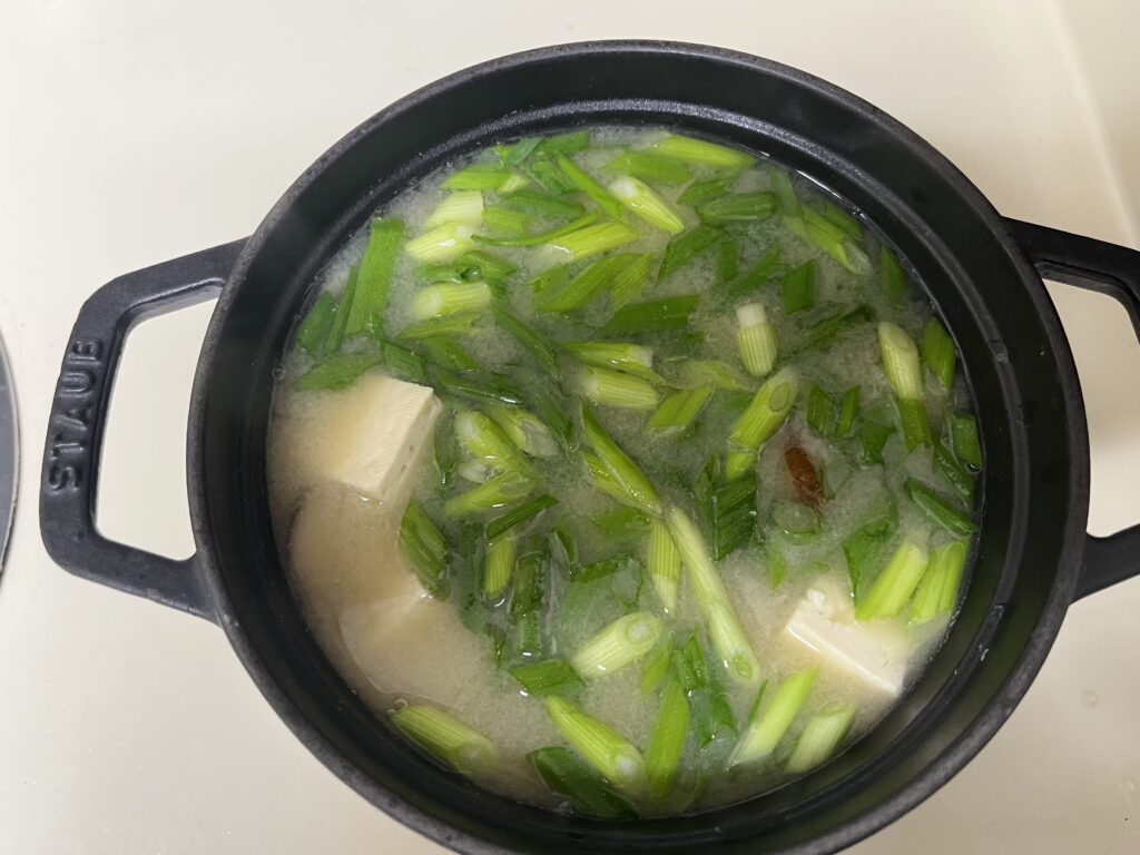 Adding sliced green onions from Trader Joe’s to finish the miso soup for a fresh and vibrant flavor