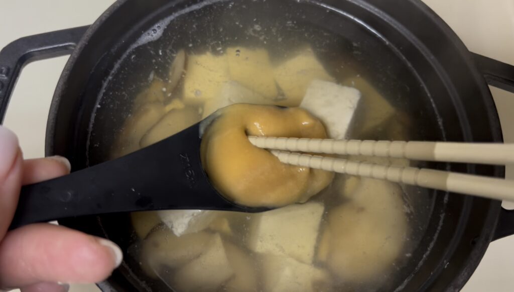 Dissolving Trader Joe’s white miso paste in a ladle using chopsticks to make authentic Japanese miso soup
