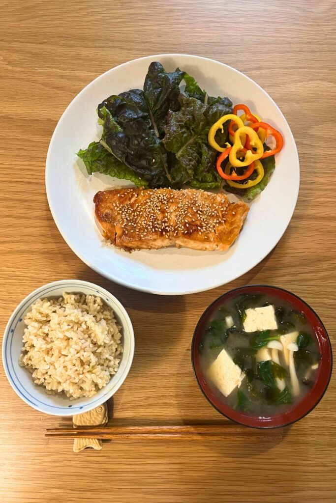 Vertical photo of miso glazed salmon with rice, lettuce, and miso soup – Japanese-style dinner made with Trader Joe’s ingredients