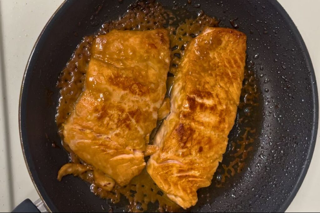 Finishing miso glazed salmon with extra glaze for a glossy look