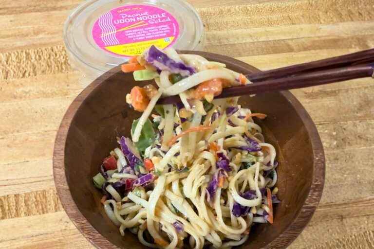 Finished Trader Joe’s Peanut Udon Noodle Salad in a bowl, lifted with chopsticks, showing soft udon noodles and vegetables