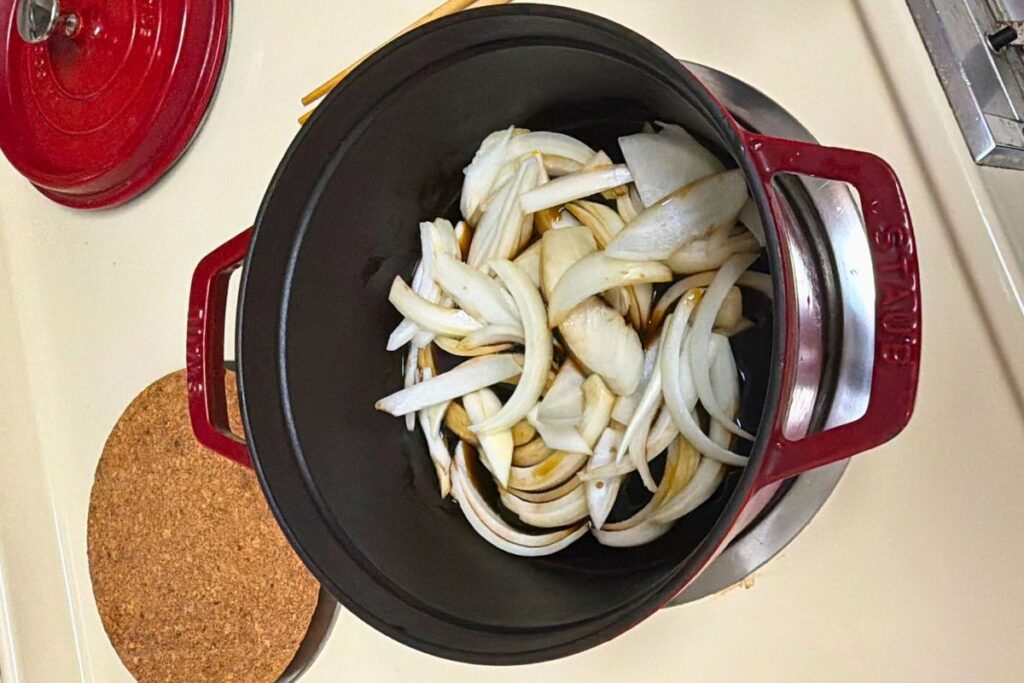 Onion simmering gently with soy sauce and maple syrup for gyudon