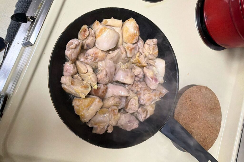 Cooking chicken thighs in a pan for teriyaki chicken rice bowl. Golden brown chicken thighs cooking for teriyaki chicken rice bowl