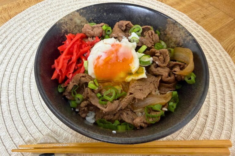 Japanese gyudon beef bowl topped with soft-cooked egg, green onion, and pickled ginger, made with Trader Joe’s ingredients