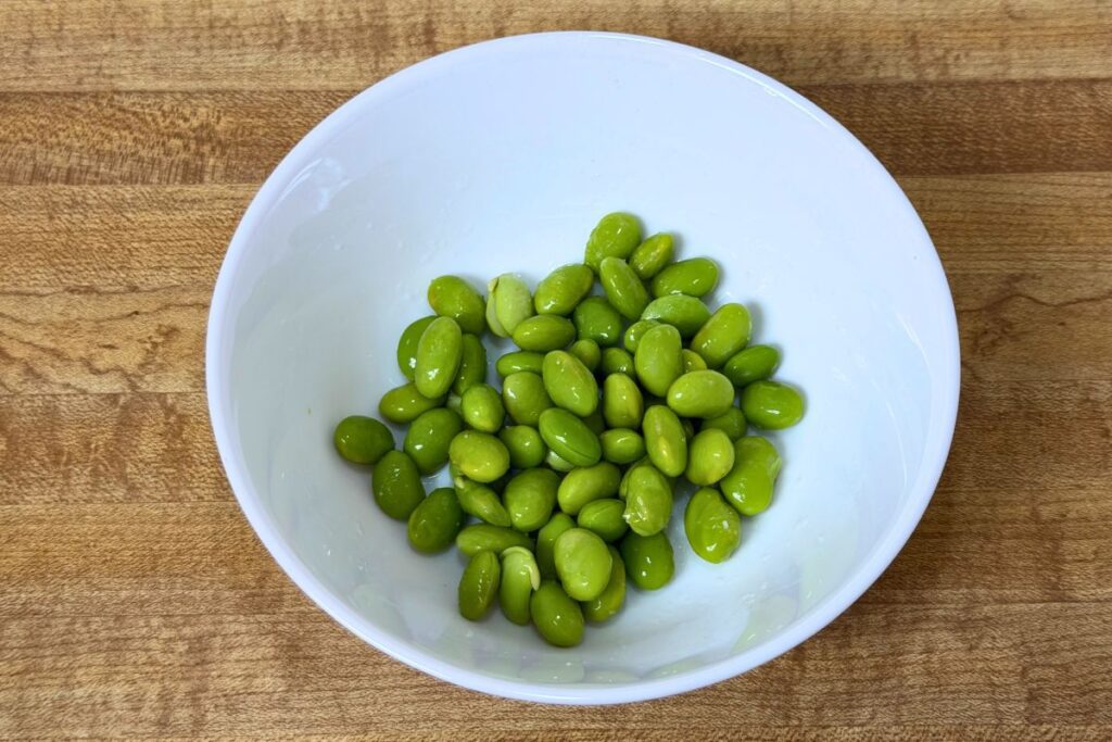 Blanched edamame prepared as the green topping for soboro don