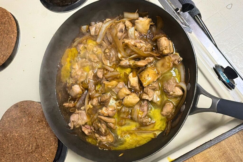 Beaten eggs being poured into the pan to make soft and fluffy oyakodon
